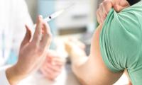 Billede er et neutralt stockphoto der viser et udsnit af en hånd der holder en nål og skal til at give en vaccination i armen på en anden person. Ingen ansigter kan ses.