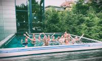 Fællesbillede fra ungeweekend august 2021, en gruppe unge smiler med armene i vejret i Hotel Vejlefjords skovbad.